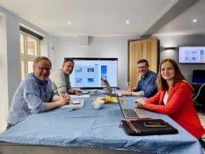 Team sitting around a desk during an early meeting to design and build Life Possum